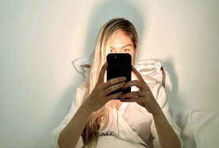 Megan Rossi in bed with phone infront of her face scrolling