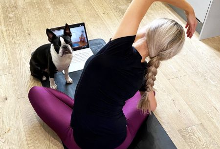 Megan Rossi on a yoga mat with laptop and dog