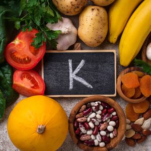 Photo of an arrangement of potassium-rich food including bananas, potatoes, garlic, tomatoes
