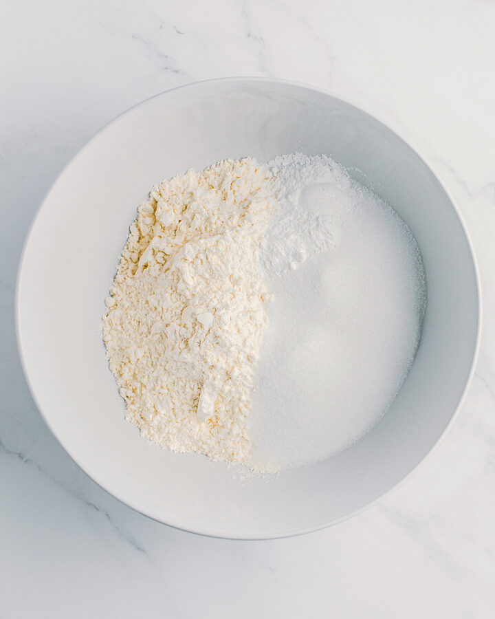 Flour, sugar, and baking powder in a bowl.