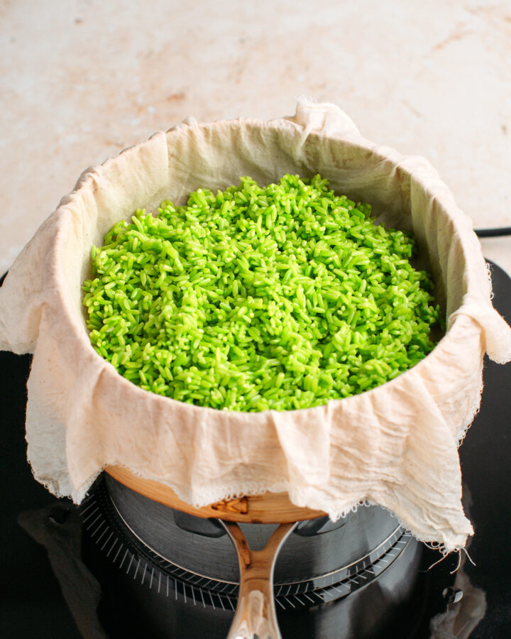 Uncooked pandan rice in a bamboo basket steamer.