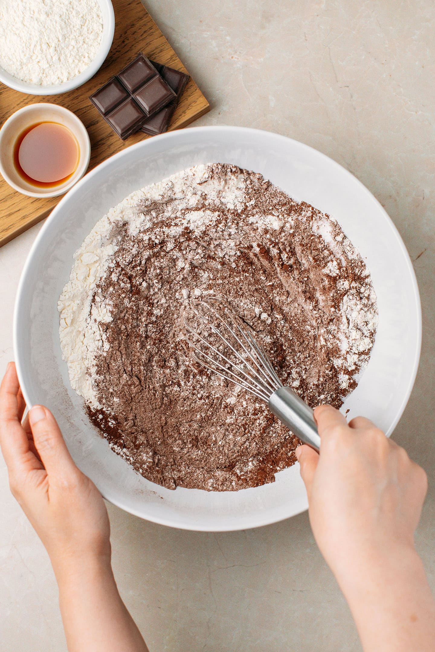 Mixing flour with sugar, cocoa powder, and salt in a mixing bowl.