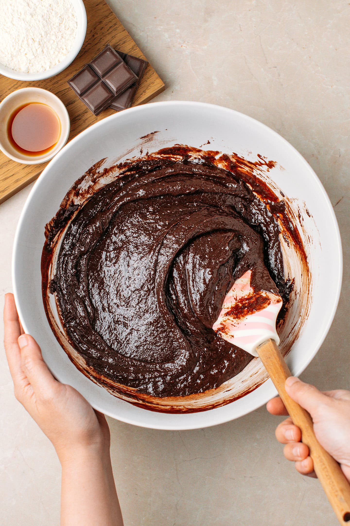 Mixing brownie batter in a white mixing bowl.