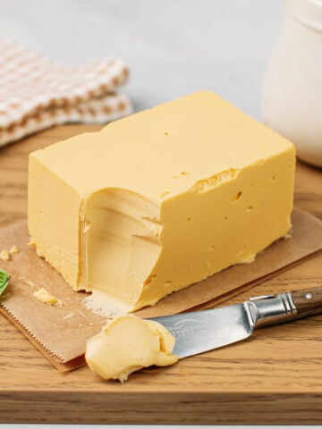 Block of vegan butter on a wood cutting board.