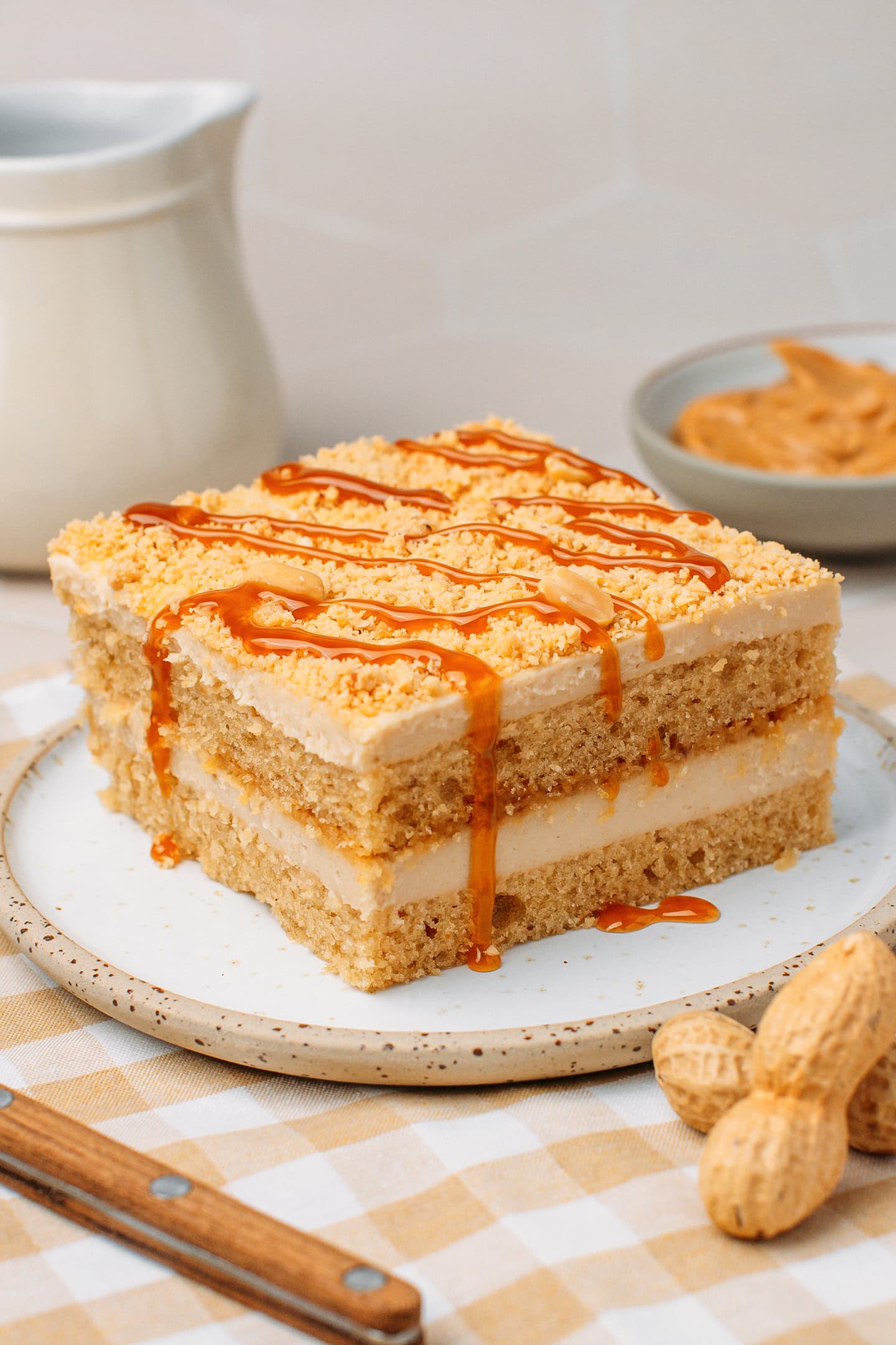 Slice of peanut tiramisu drizzled with salted caramel on a small plate.