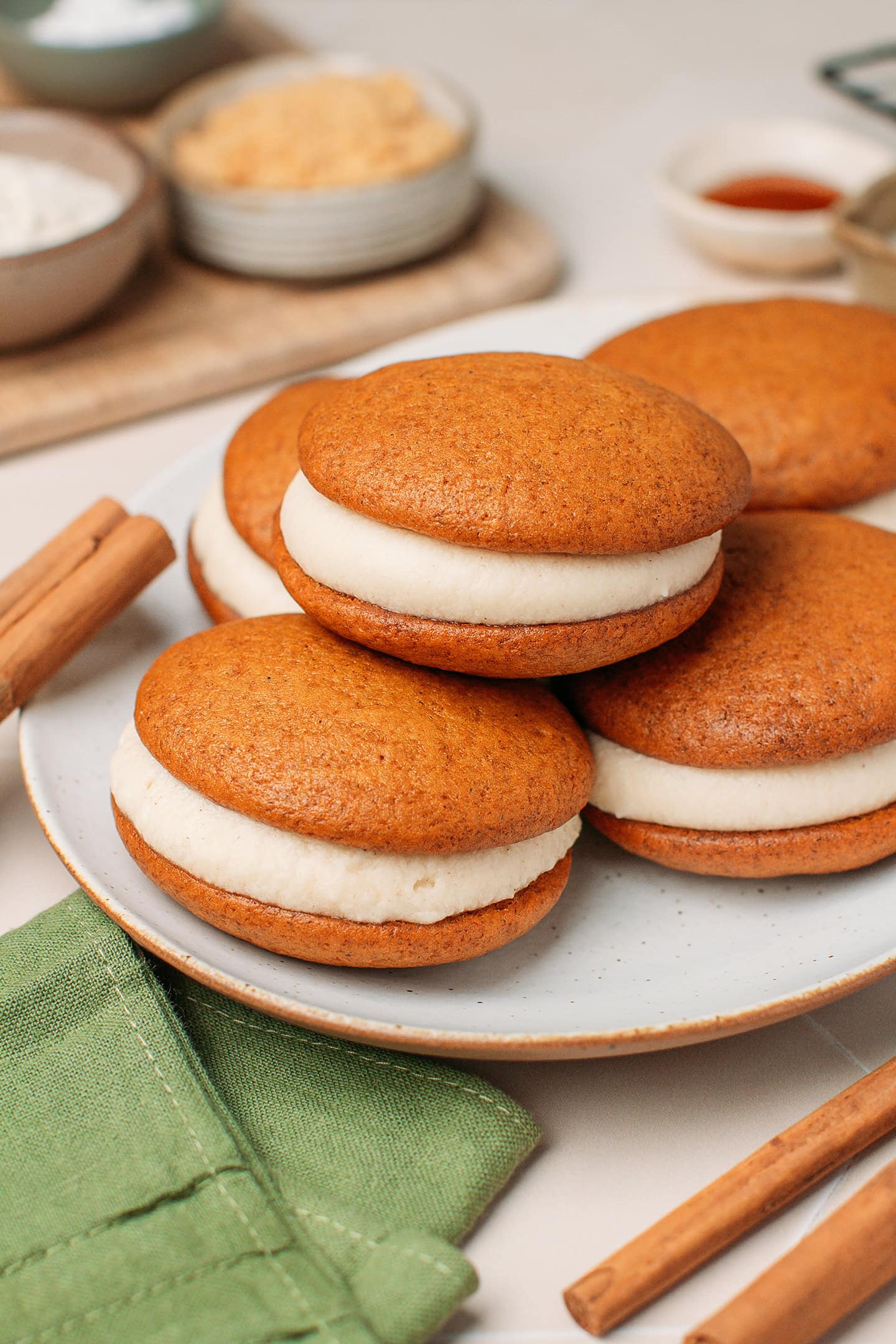 Pumpkin whoopie pies stacked on a plate.