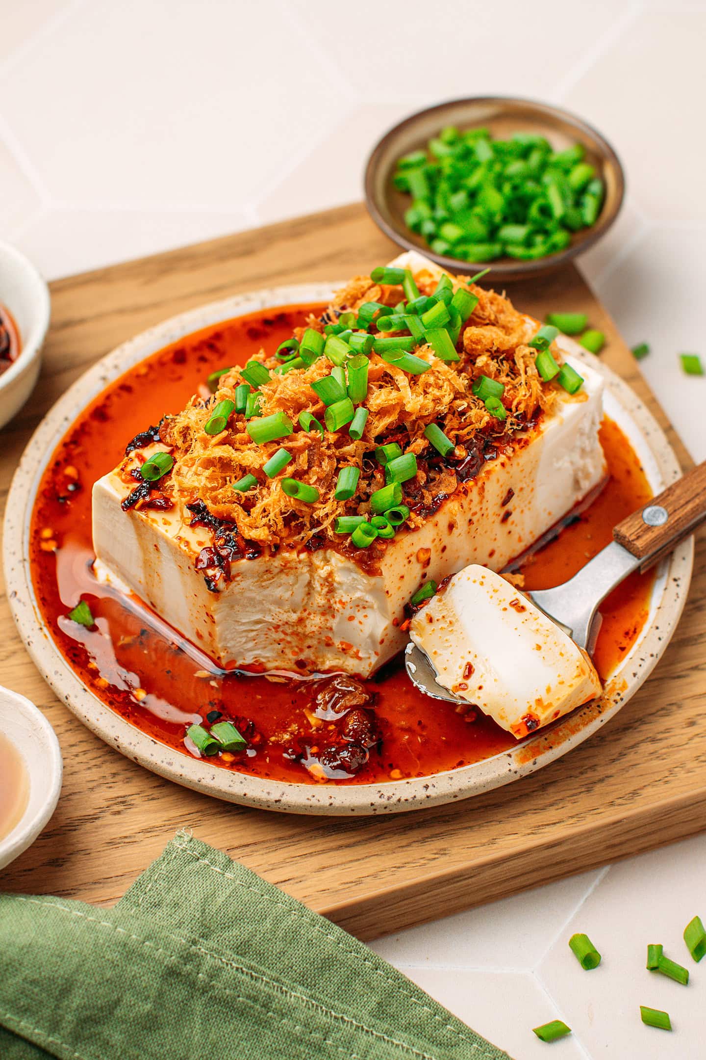 Silken tofu topped with chili crisp sauce, vegan meat floss, and chopped green onions.