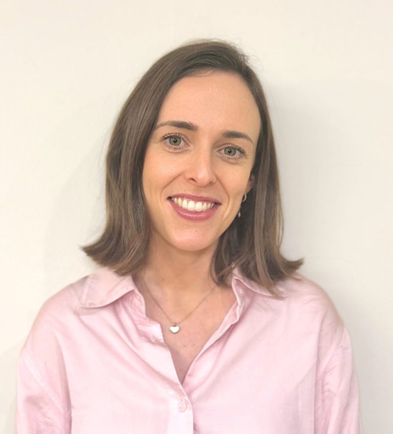 Alice Twomey, who has a short, brown bob. She is smiling and wearing a light pink shirt